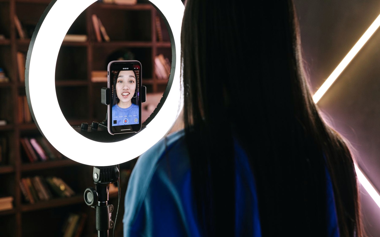 Creator recording a live social video with a phone and ring light