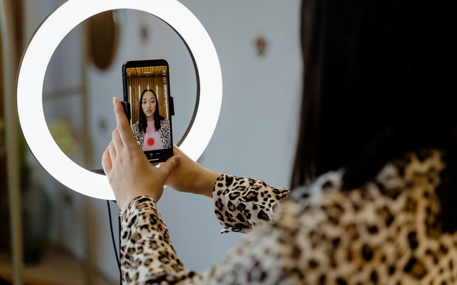 Creator filming short-form social content with a smartphone and ring light